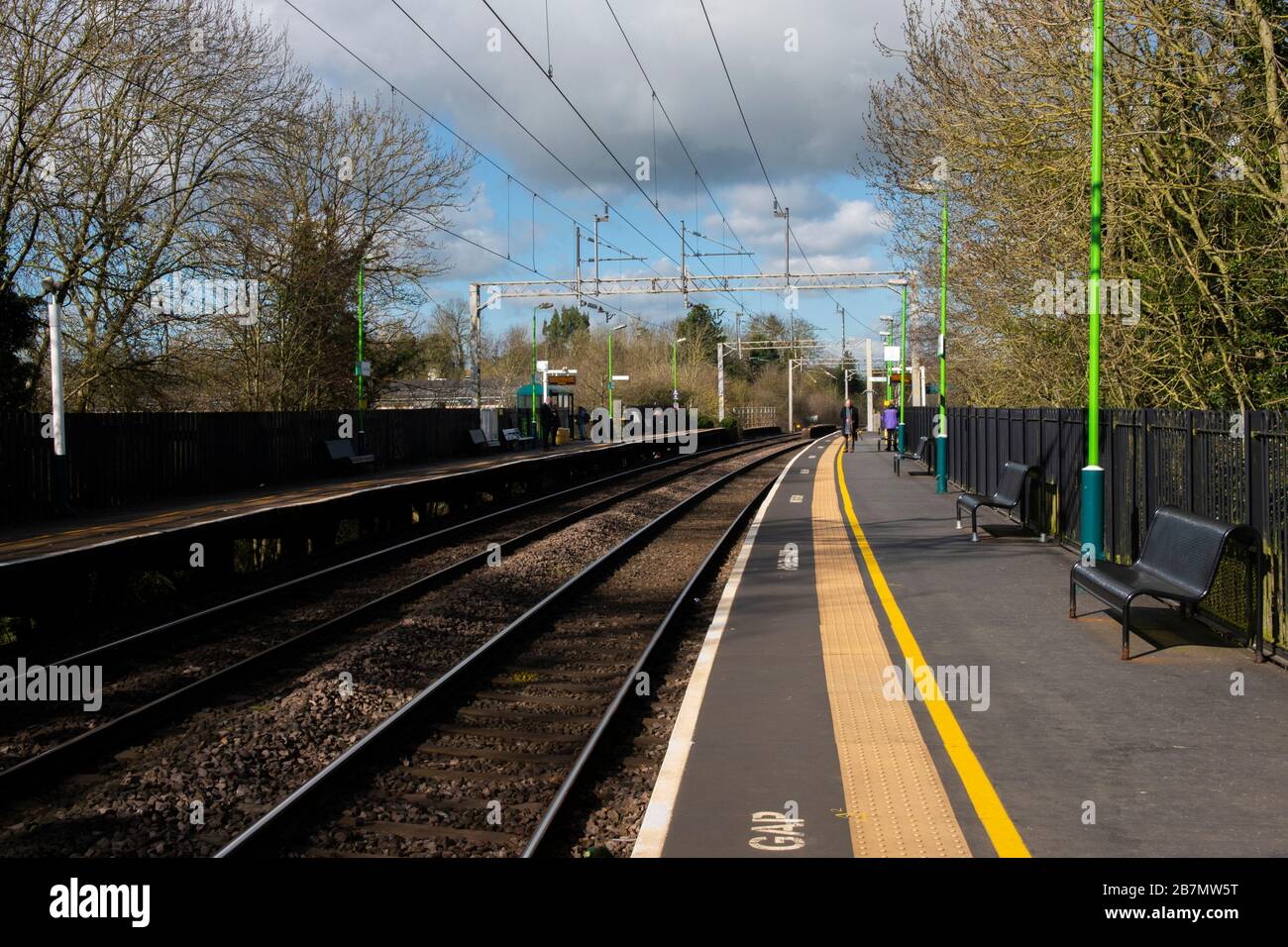 Elevated English railway station with lines leading away along the platform on a sunny winter's day Stock Photo