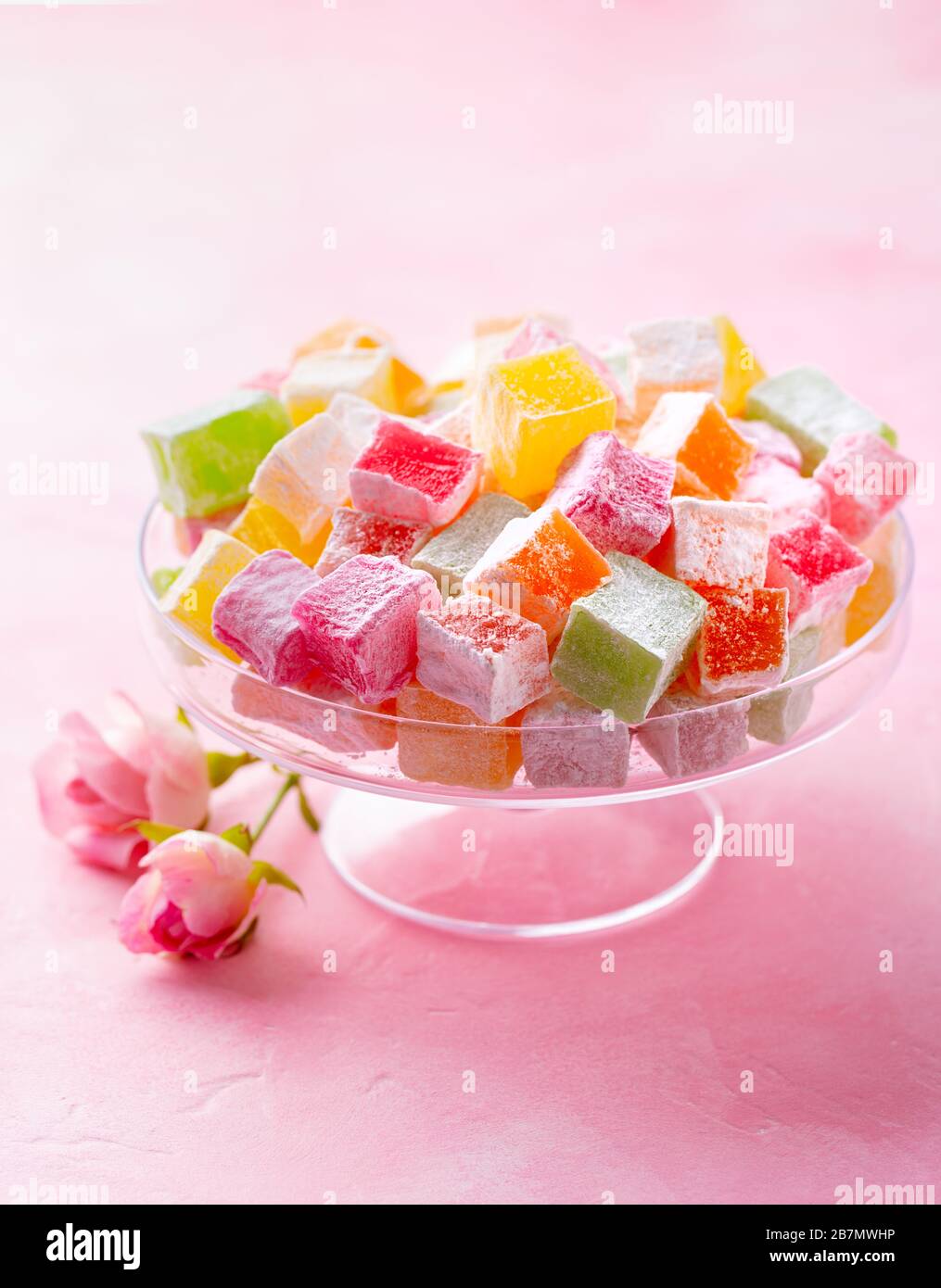 Assorted Turkish delights on glass cake stand. Pink background. Copy space. Stock Photo