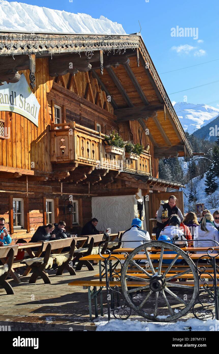 Saalbach, Austria - February 18, 2013: Unidentified people relax and enjoy a sunny winter day on mountain inn in ski resort Saalbach-Hinterglemm in Sa Stock Photo