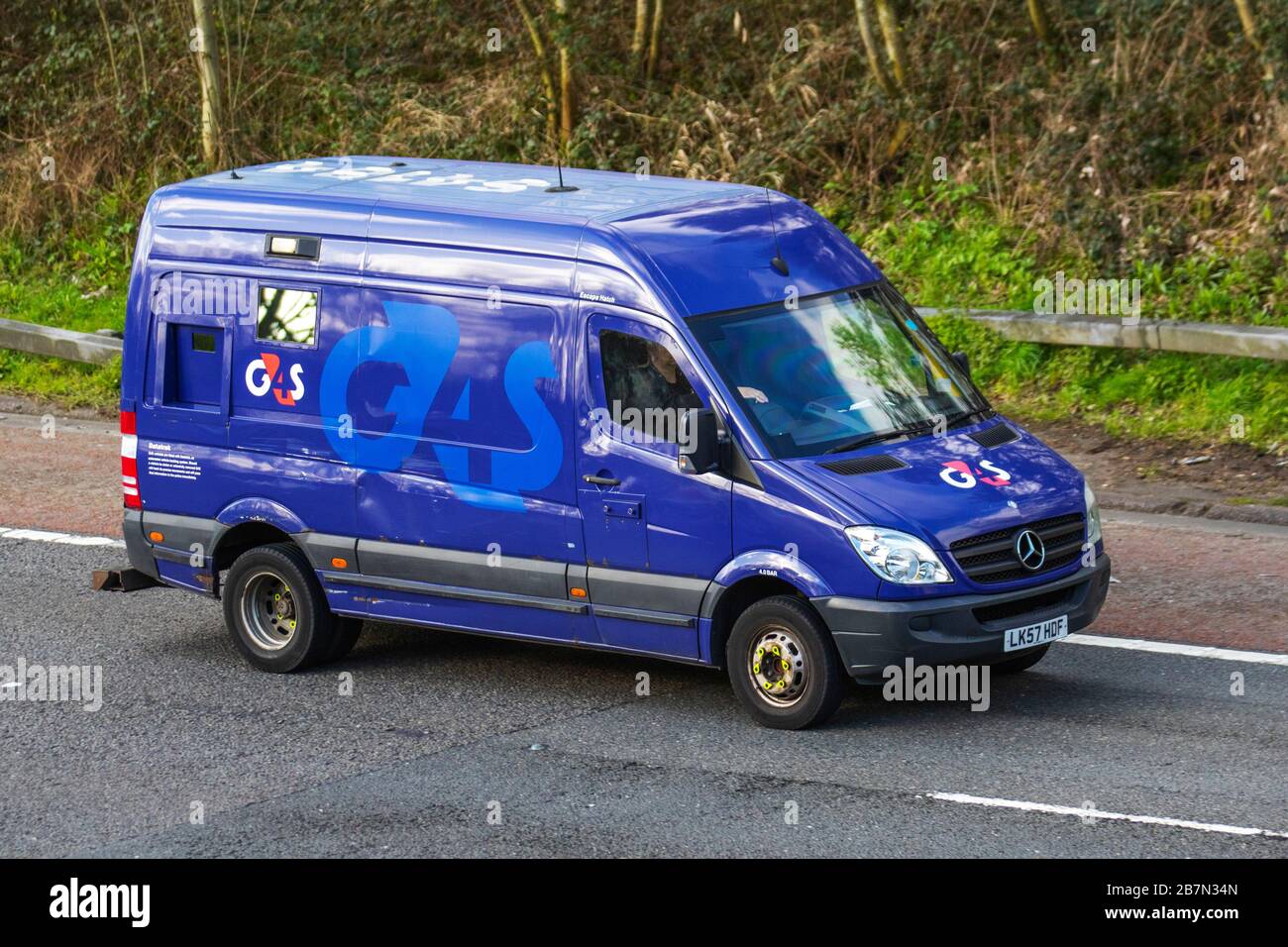 Blue Mercedes Benz G4s armoured security van driving on the M6 motorway, UK Stock Photo