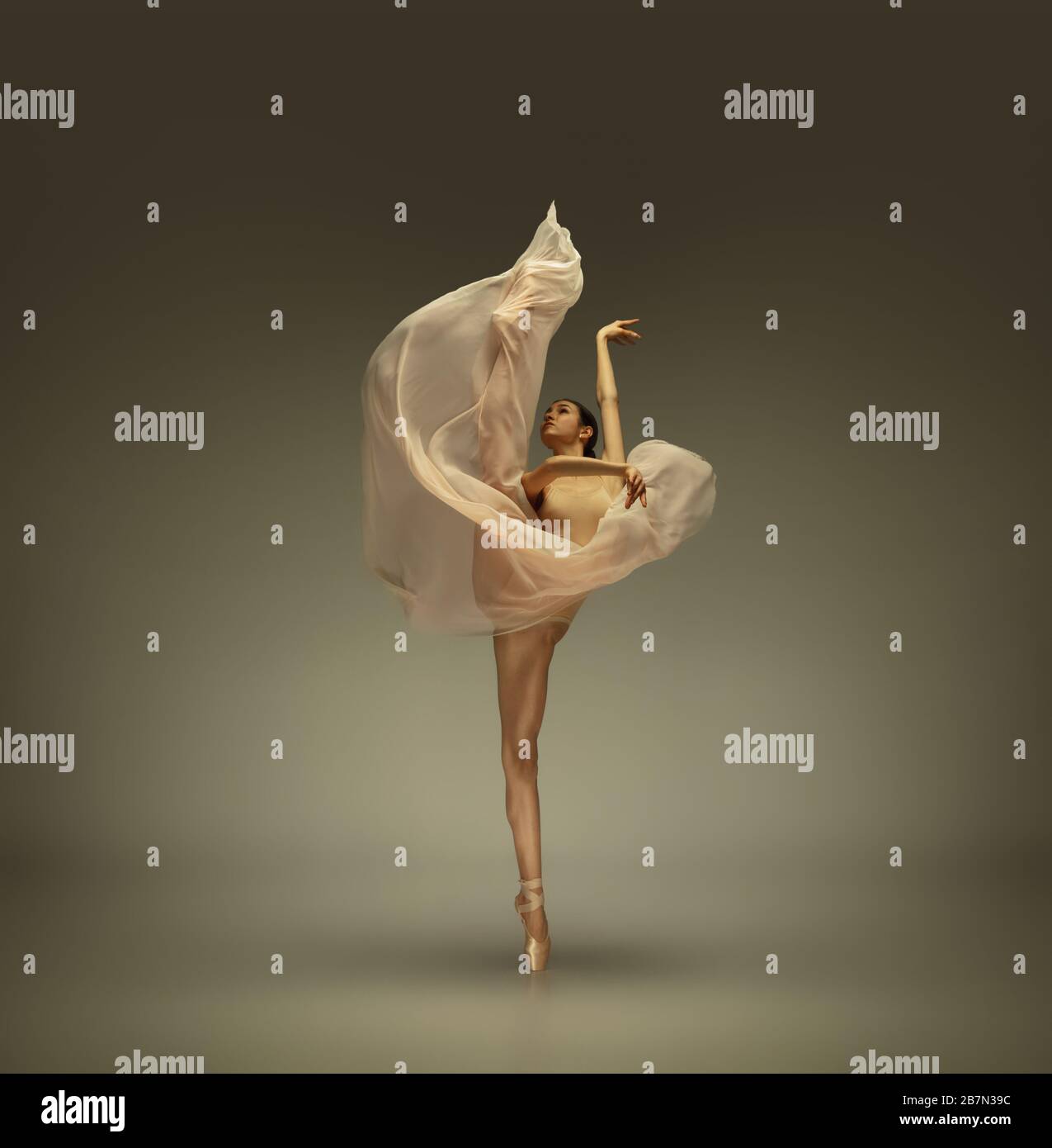 Graceful classic ballerina dancing, posing isolated on grey studio  background. Tender beige cloth. The grace, artist, movement, action and  motion concept. Looks weightless, flexible. Fashion, style Stock Photo -  Alamy