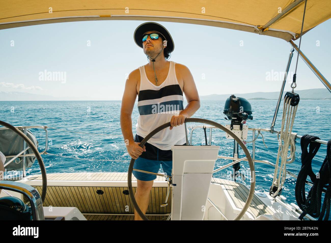 Male skipper on the steering wheel of a yacht. Sailing and yachting concept Stock Photo Alamy
