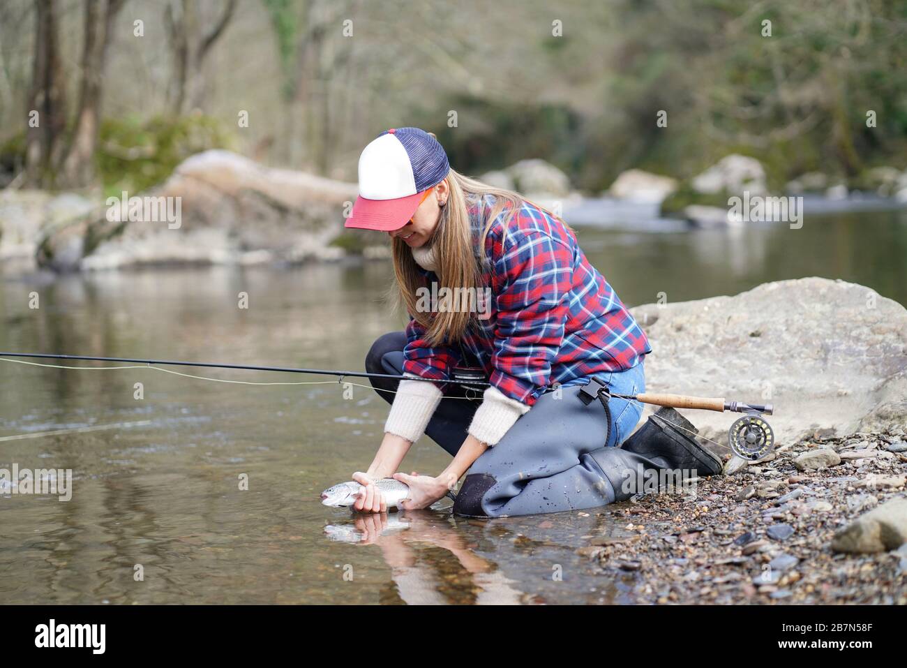 woman catching rainbow trout fly in river Stock Photo Alamy