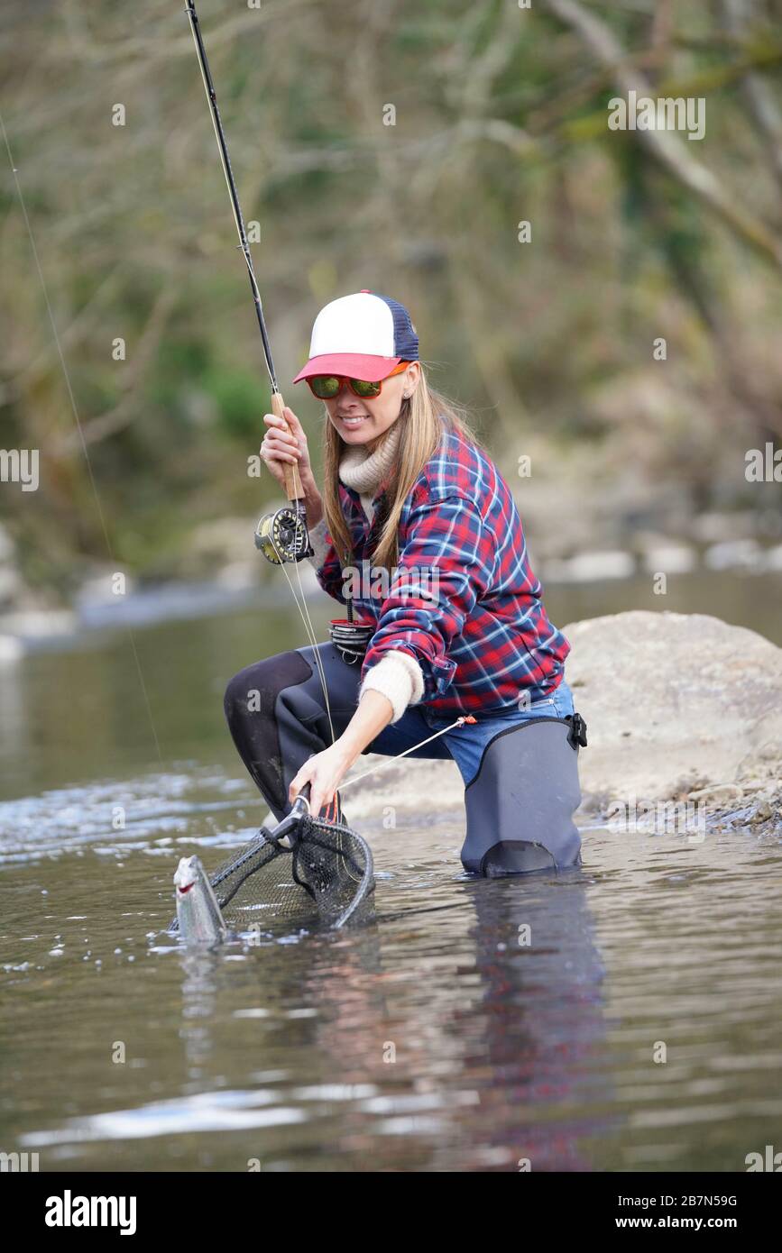 woman catching rainbow trout fly in river Stock Photo Alamy