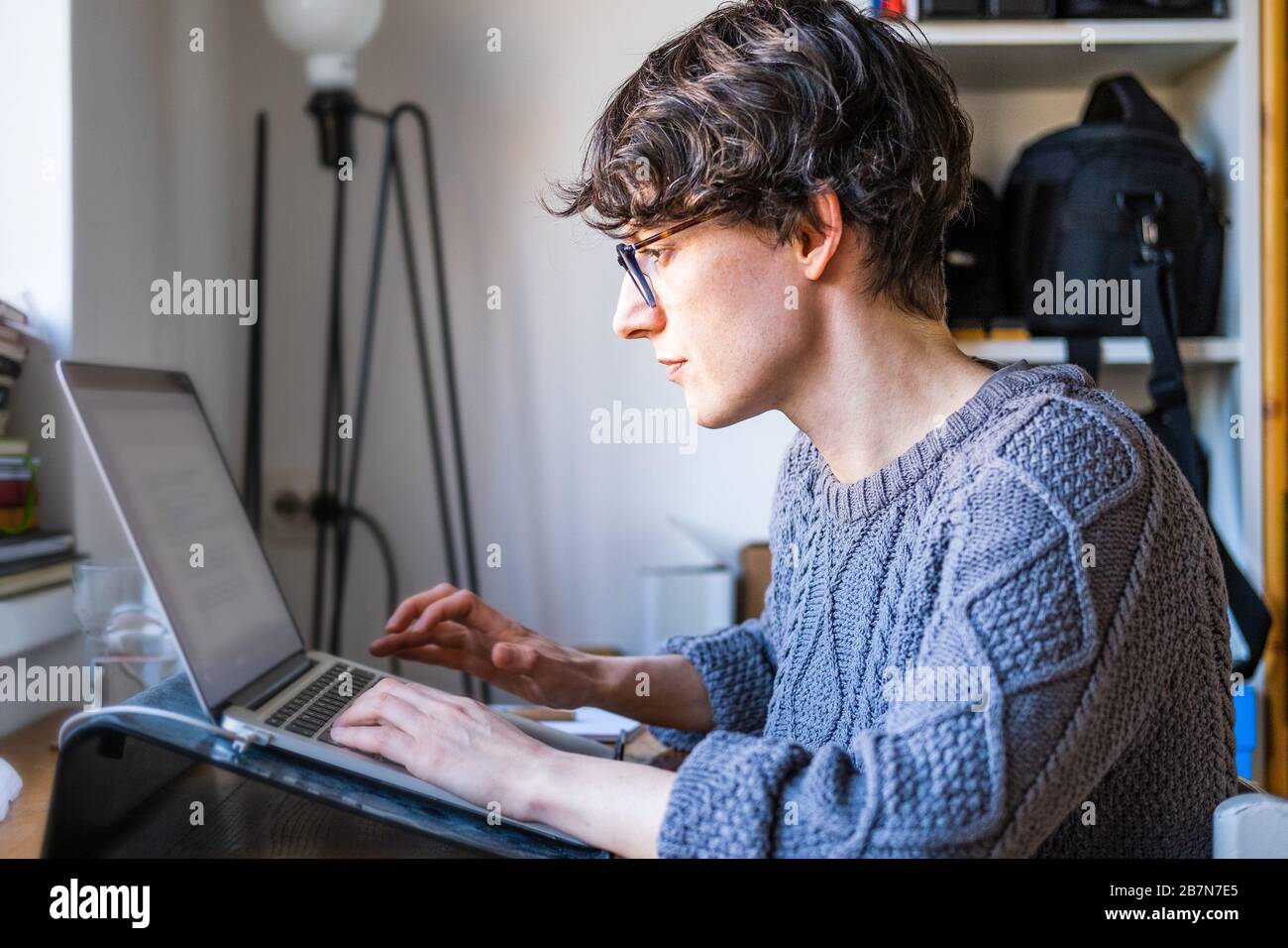 Young woman working from home. Caucasian short hair employee woman with glasses working online from home on computer laptop Stock Photo