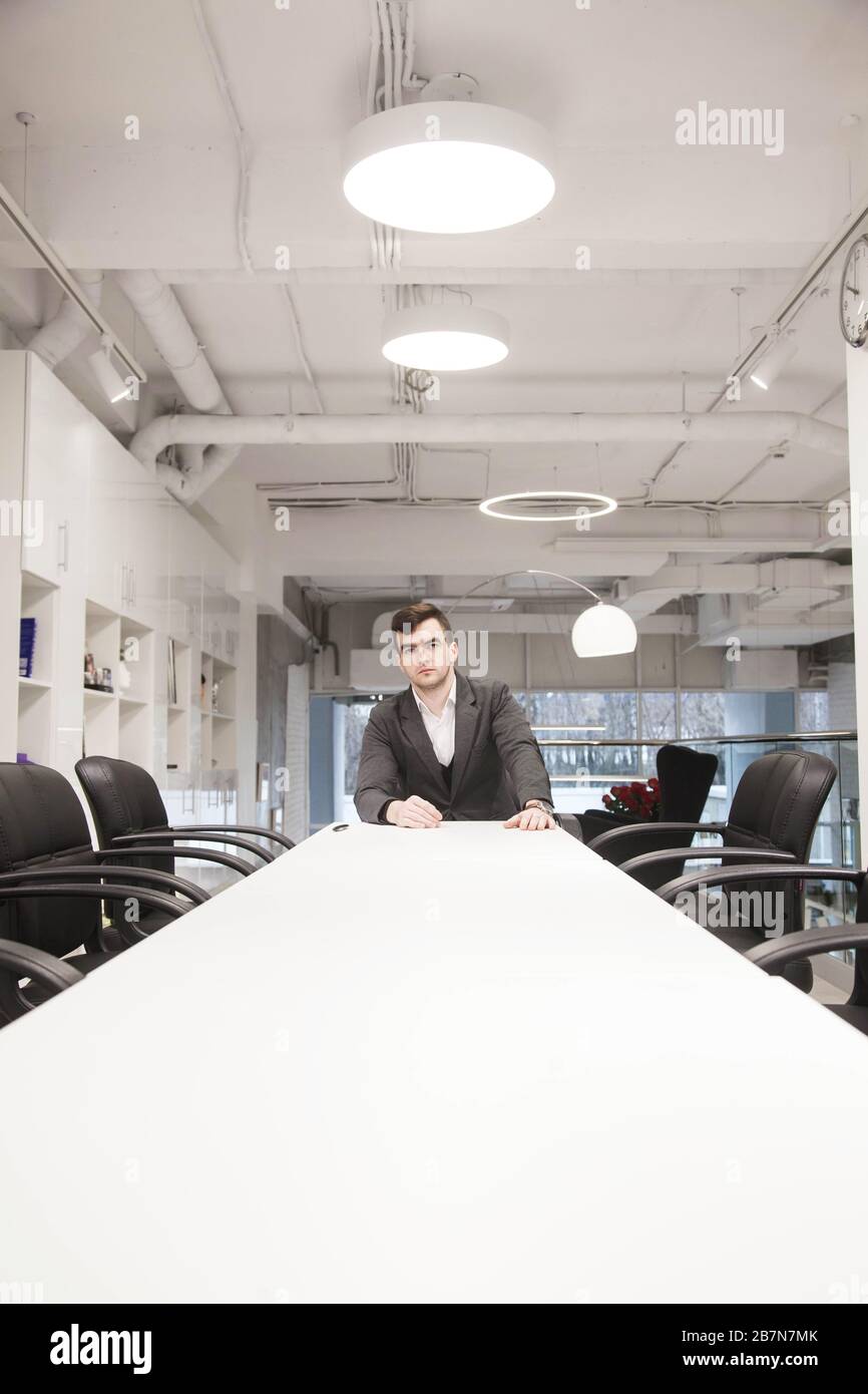 young businessman in a loose suit works in a light office Stock Photo