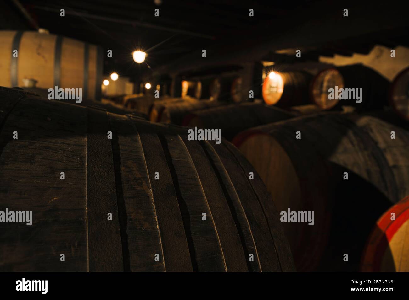 View at wine in wooden barrels stored for aging in the cellar Stock Photo