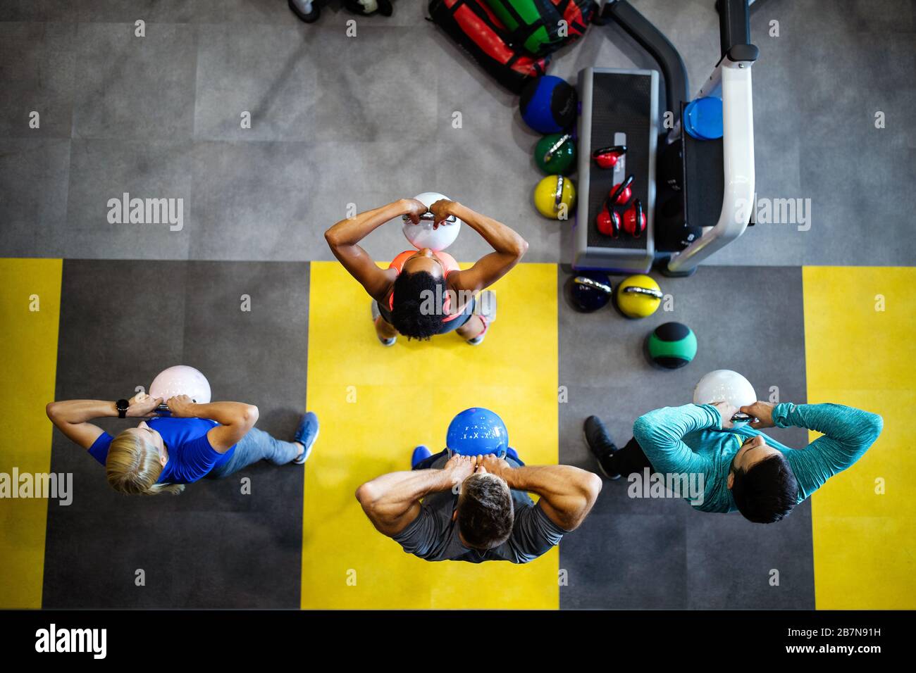 Group of fit people in gym training. Multiracial group of friends working out together Stock Photo