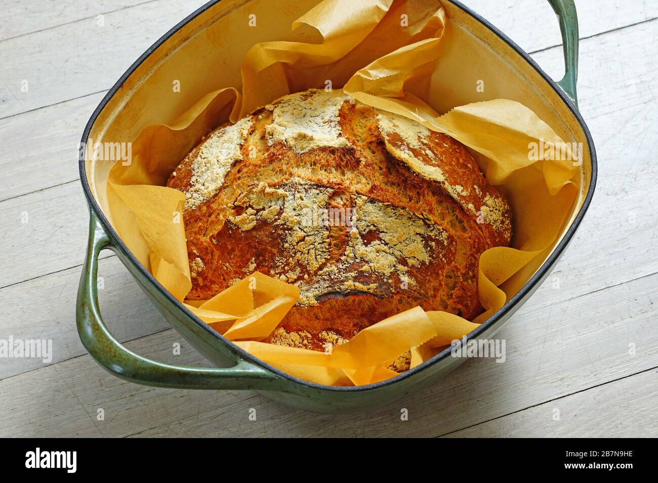 Loaf of crusty miracle overnight no knead bread baked on parchment