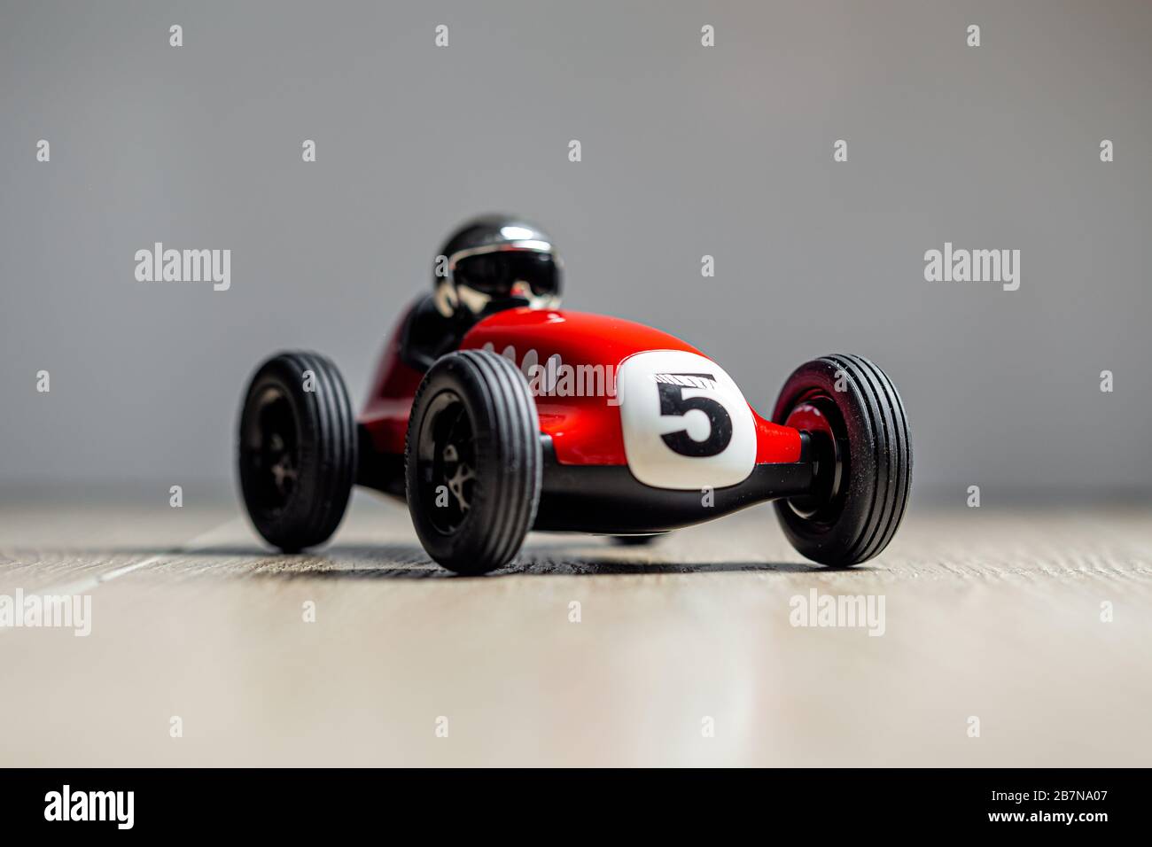 Red toy racing car with number five painted on it Stock Photo