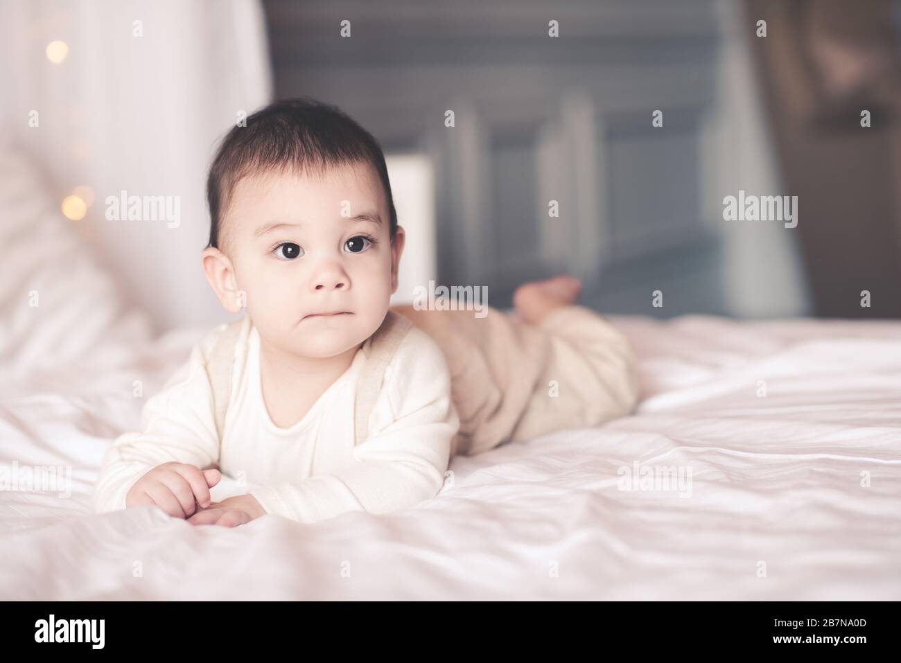 Cute baby boy under 1 year old crawling in bed closeup. Looking ...