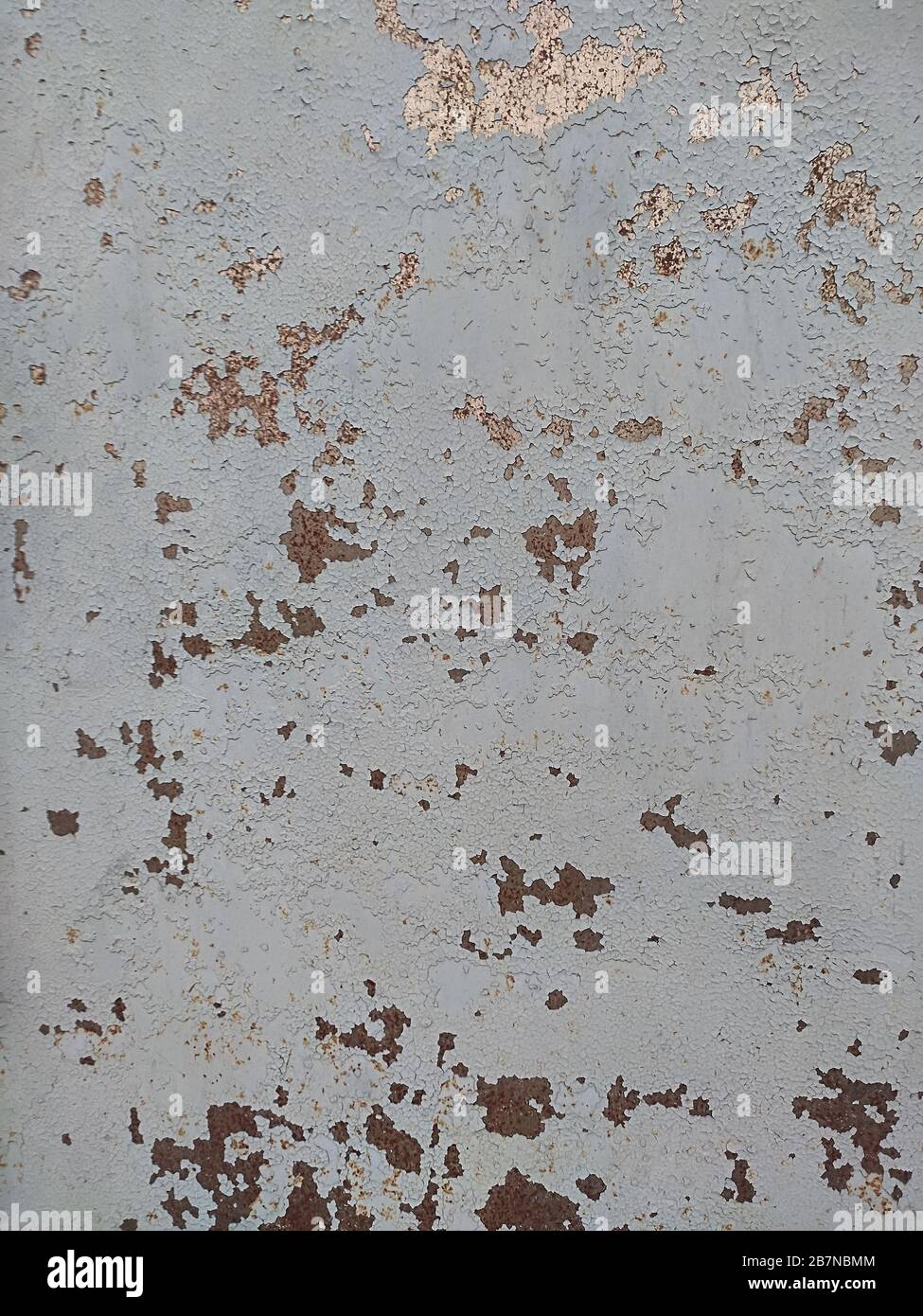 Corroded metal background. Rusted white painted metal wall. Rusty metal background with streaks of rust. Rust stains. The metal surface rusted spots. Stock Photo