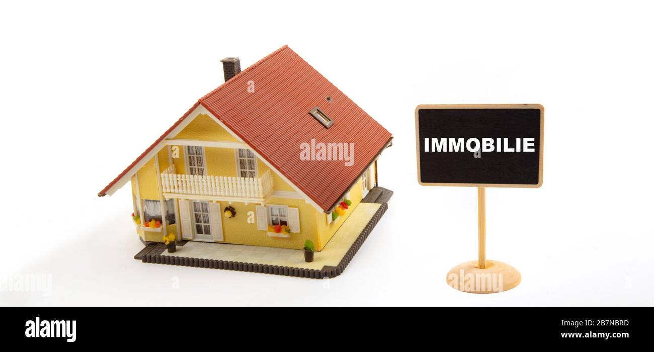 Immobilie means Property real estate market. Concept Business Real Estate with Toy House and little Blackboard Sign on white Background Stock Photo