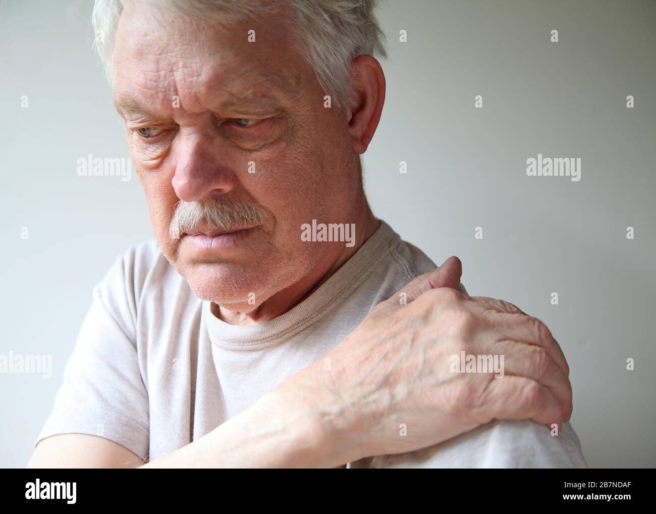 Senior experiences soreness in his shoulder joint Stock Photo
