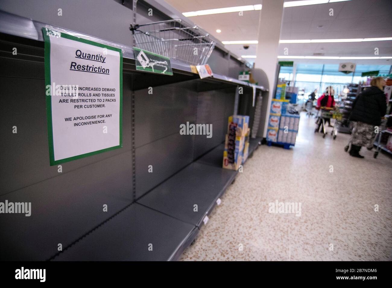 Empty shelves and quantity restriction signs in a Morrisons supermarket
