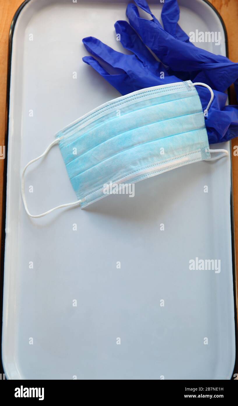 Face mask and plastic gloves on a white tray with copy space Stock Photo