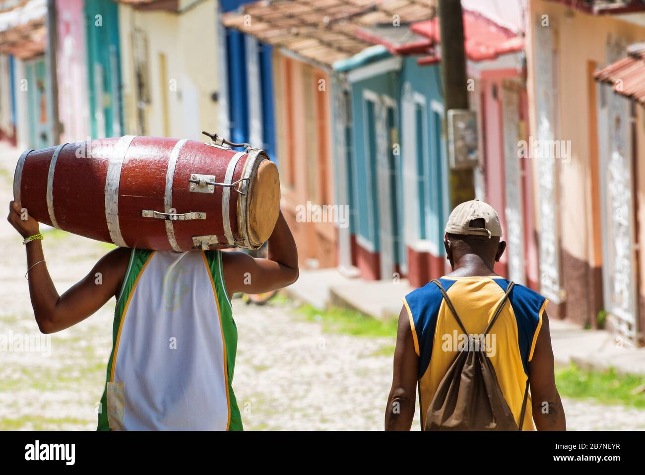 Salsa musician carrying a conga while walking with a friend in the streets of Trinidad Cuba Stock Photo