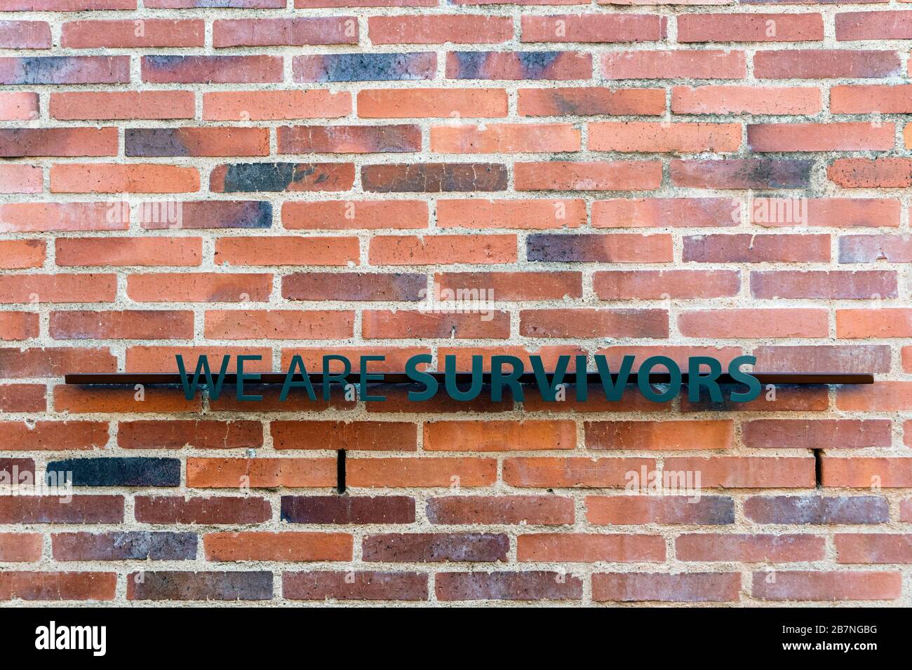 Johannesburg, South Africa - May 25, 2019: We are Survivors sign on brick wall in Apartheid Museum. Stock Photo