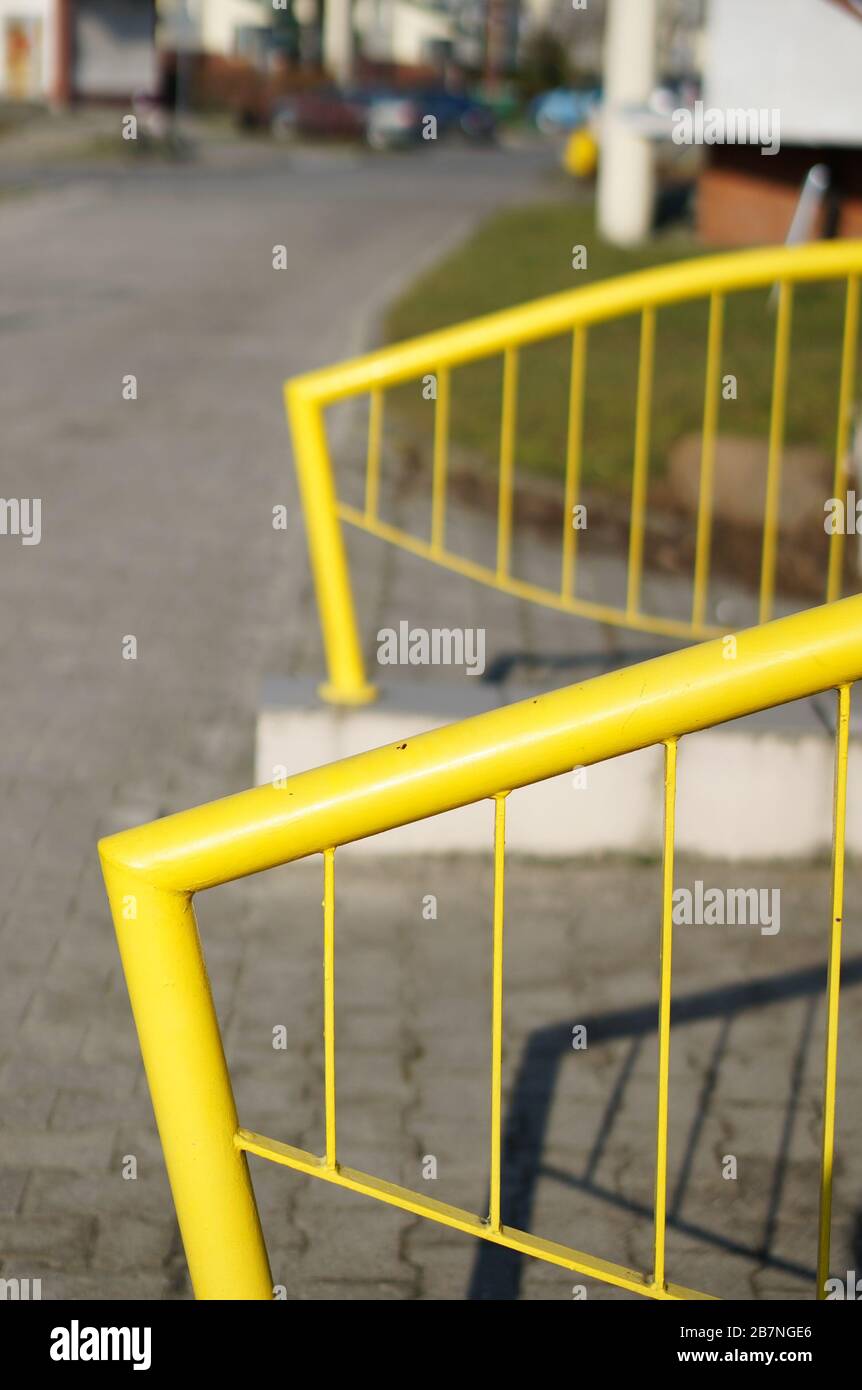 Closeup shot of yellow metal railings on the sidewalk Stock Photo - Alamy