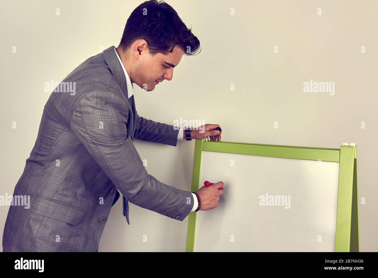 Young man writing on whiteboard Stock Photo