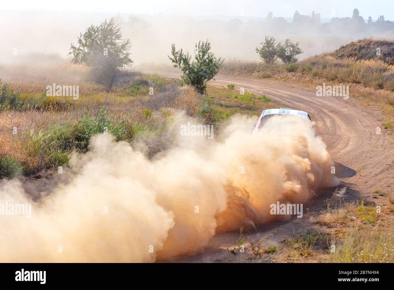 Summer dry dirt road. Sunny day. A car picks up a lot of dust at high speed Stock Photo