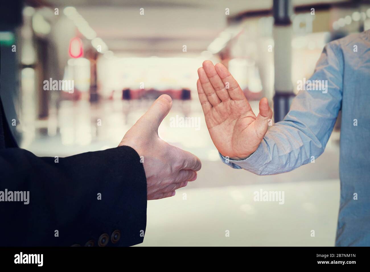 man refusing hand shake with her friend to protect herself from coronavirus in public areas. Prevention of fight against pandemic. Non-contact greetin Stock Photo