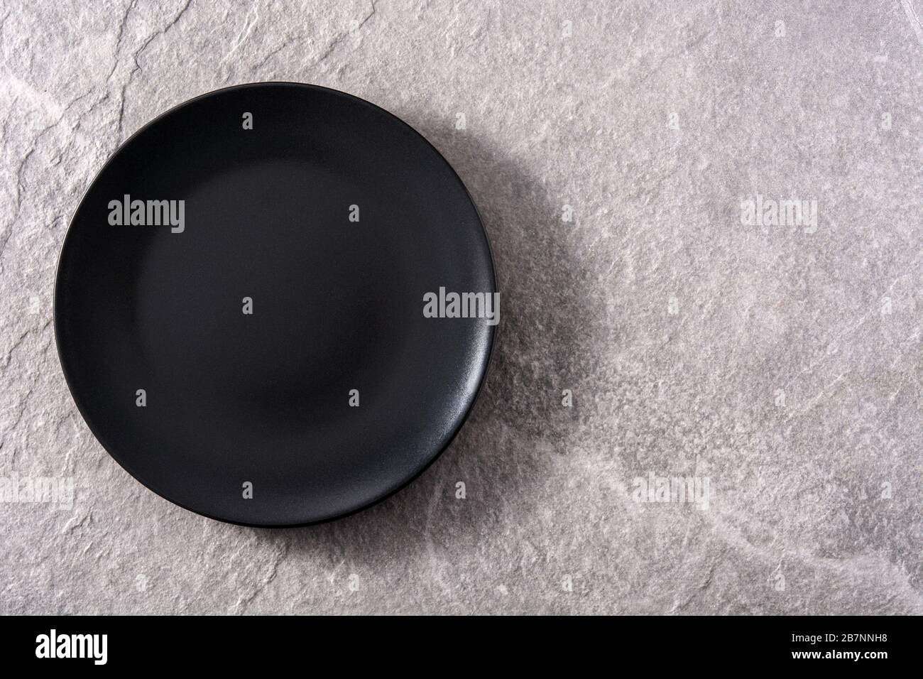 Empty black plate on gray background Stock Photo