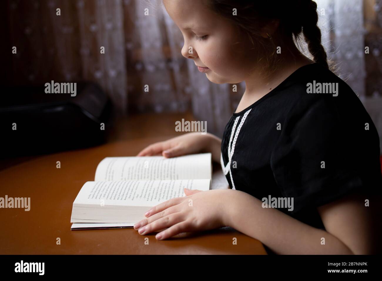 little girl reading a book at home, home study Stock Photo - Alamy