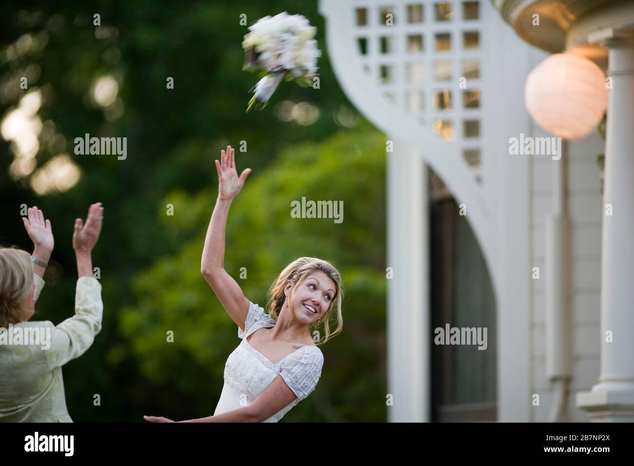 Young adult woman throwing a bouquet on her wedding day Stock Photo Alamy