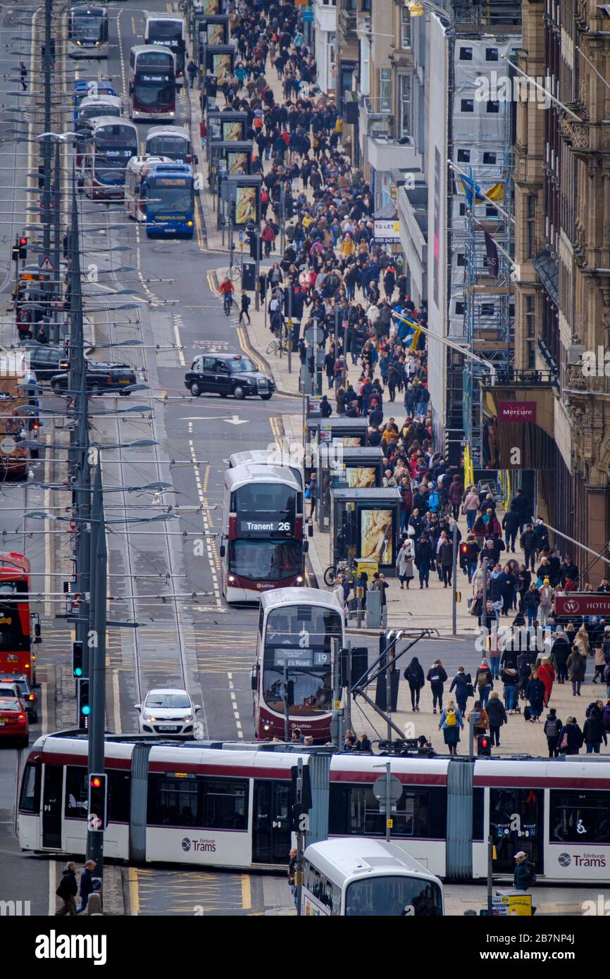 Busses and trams travel up and down Princes Street, the premier shopping street in Edinburgh city centre. Stock Photo