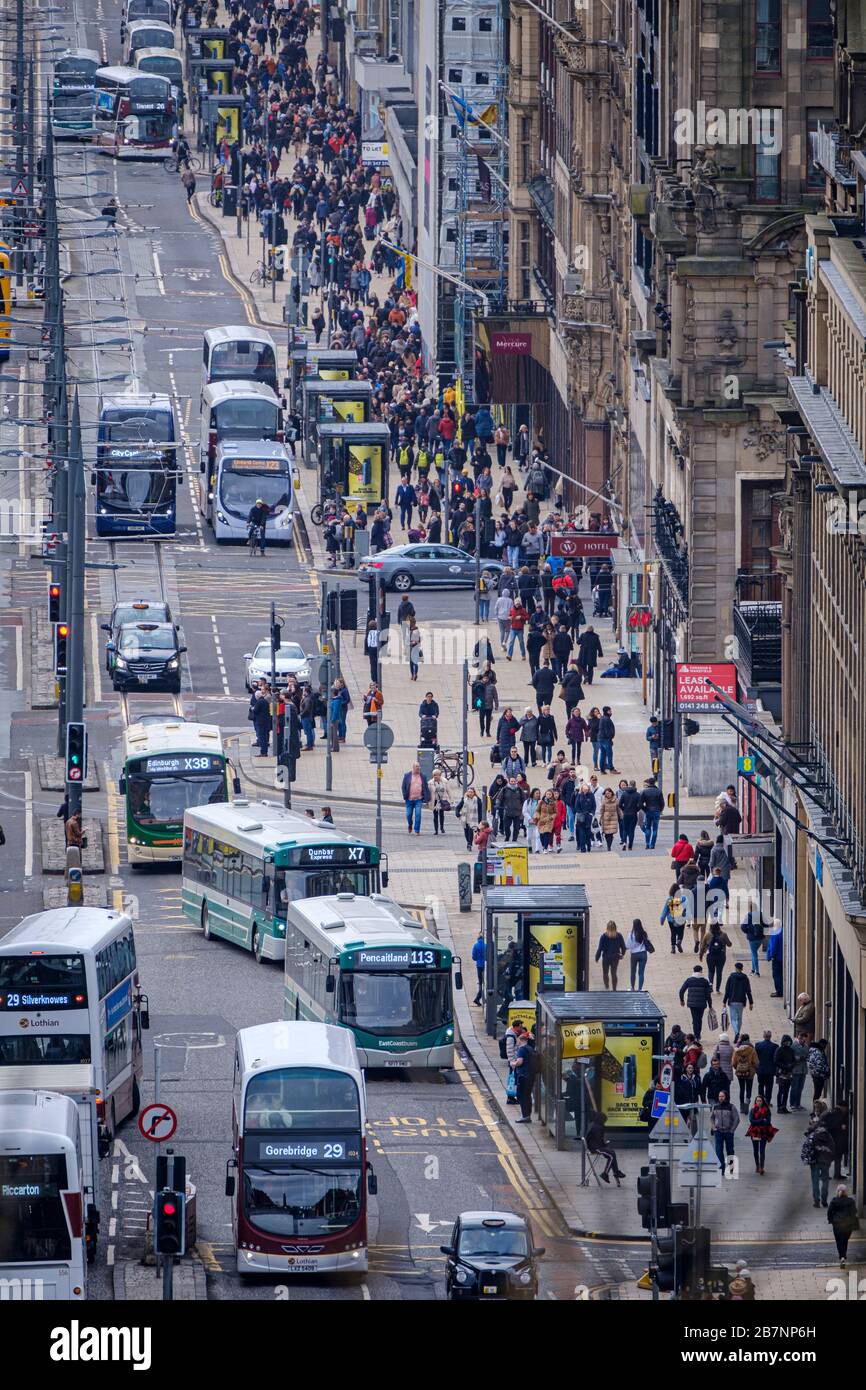 Busses and trams travel up and down Princes Street, the premier shopping street in Edinburgh city centre. Stock Photo