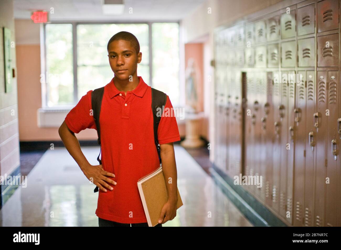 Teenage boy standing in school corridor Stock Photo - Alamy