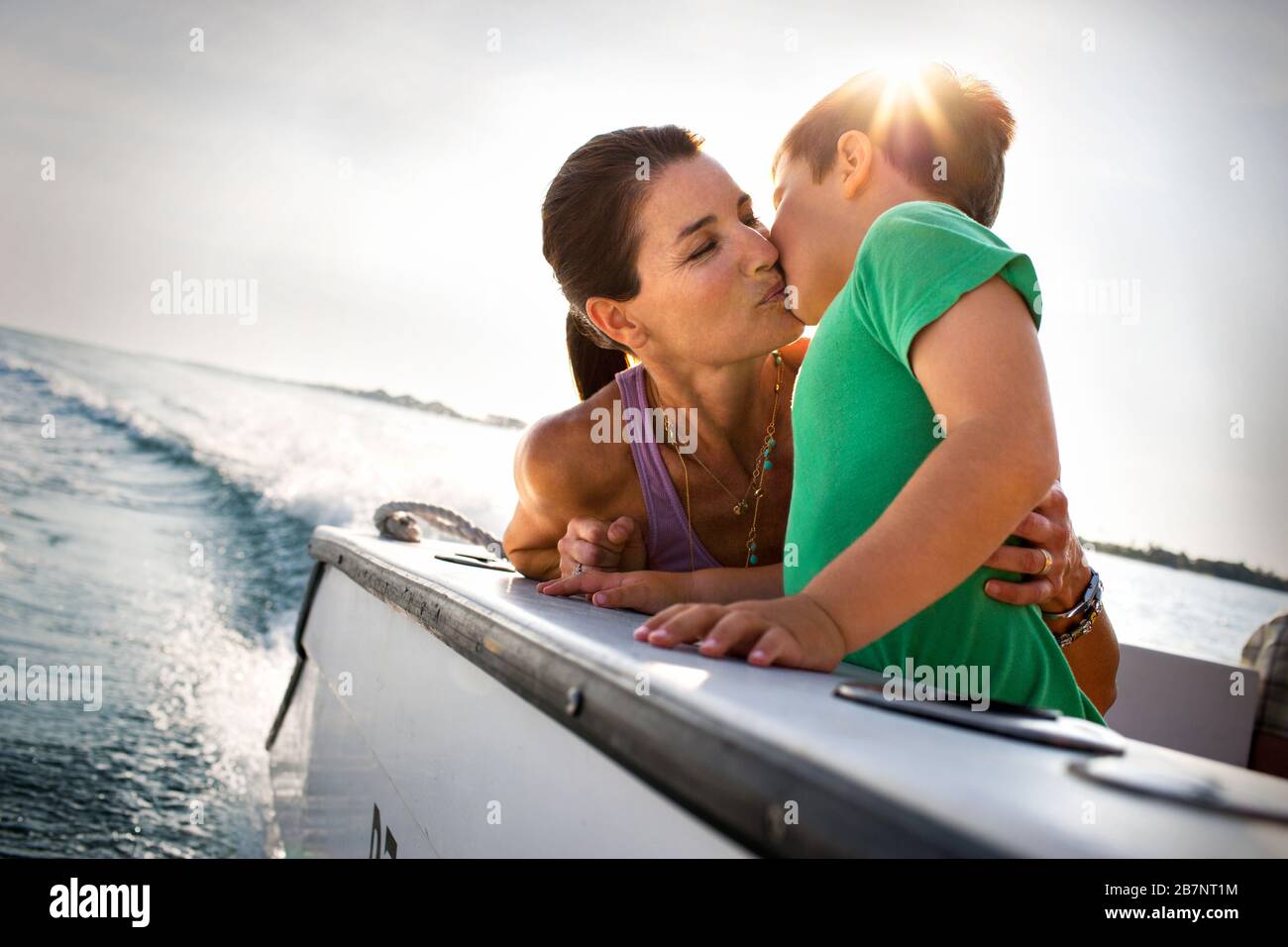 Happy mother kissing her son on the deck of a boat Stock Photo - Alamy