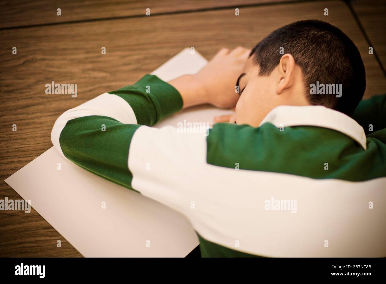 Teenage boy sleeping at a desk. Stock Photo
