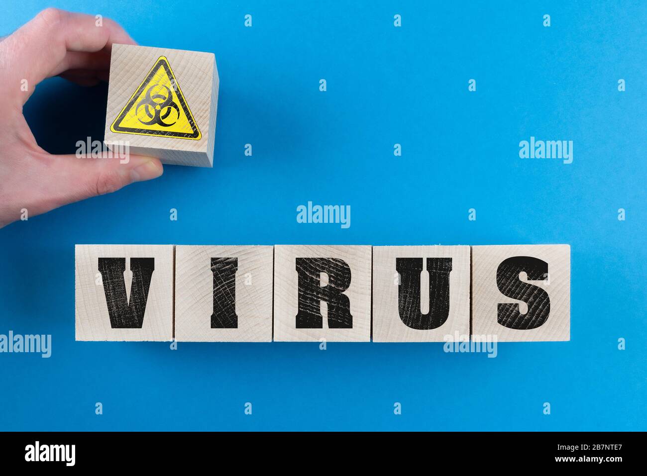 word VIRUS and biohazard symbol on wood cubes, corona virus covid-19 outbreak warning concept Stock Photo