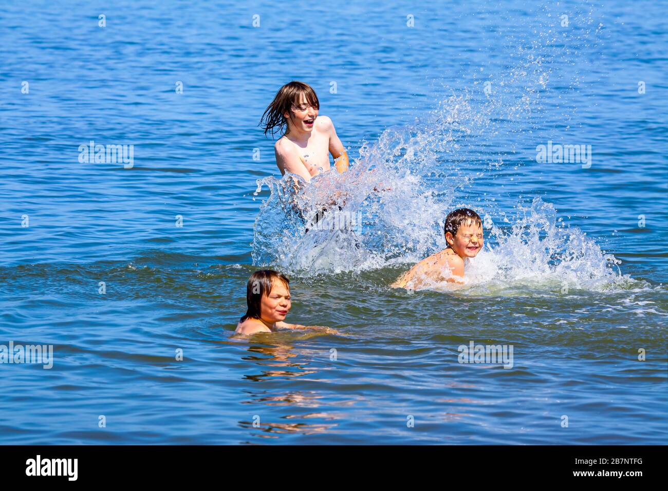 Finally vacation - the three children played carefree and happy in the North Sea. Stock Photo