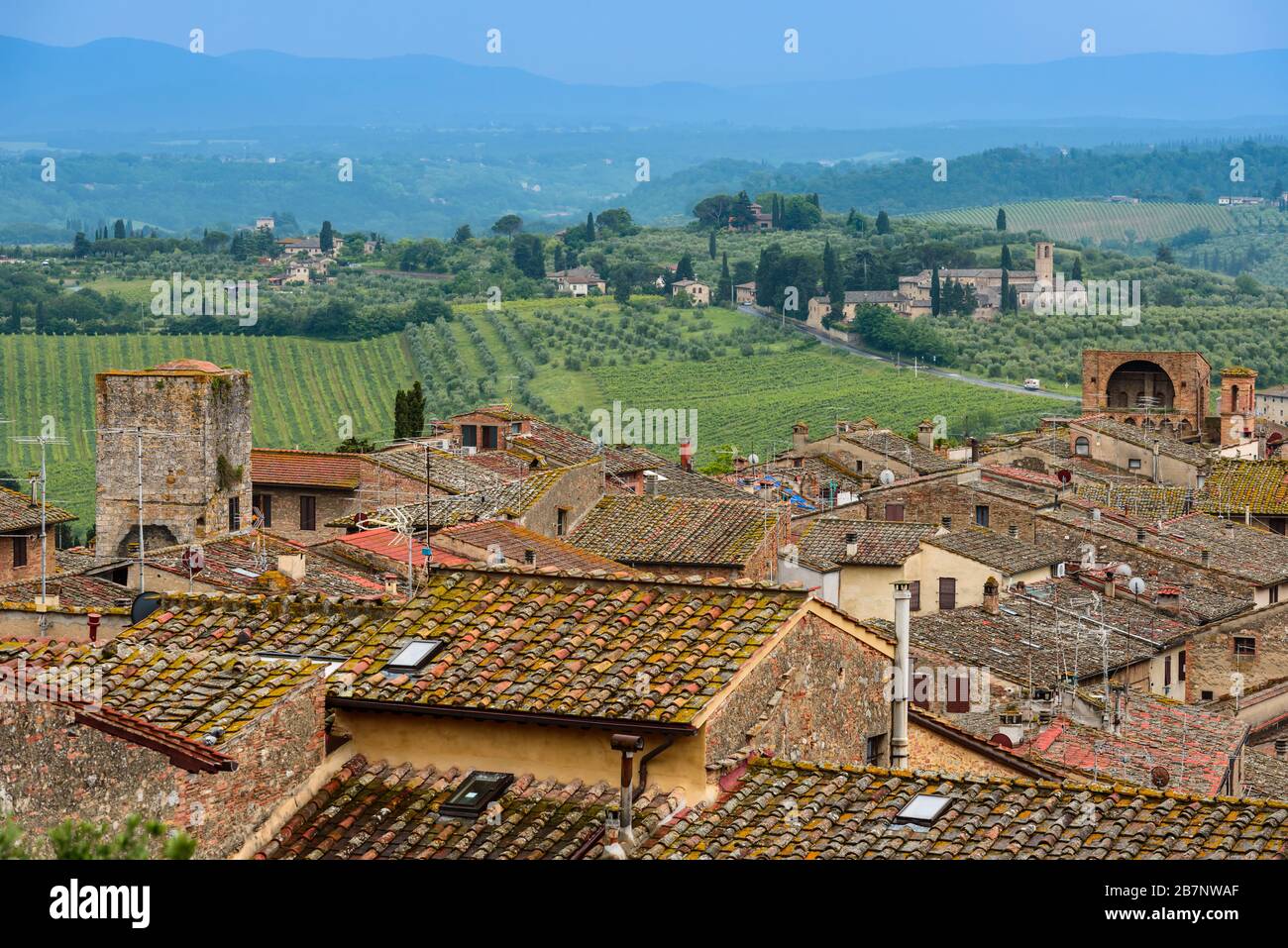 Rooftops of San Gimignano, Tuscan countryside with rolling hills and Santa Maria Assunta a Monte Oliveto Minore from Parco della Rocca, San Gimignano. Stock Photo