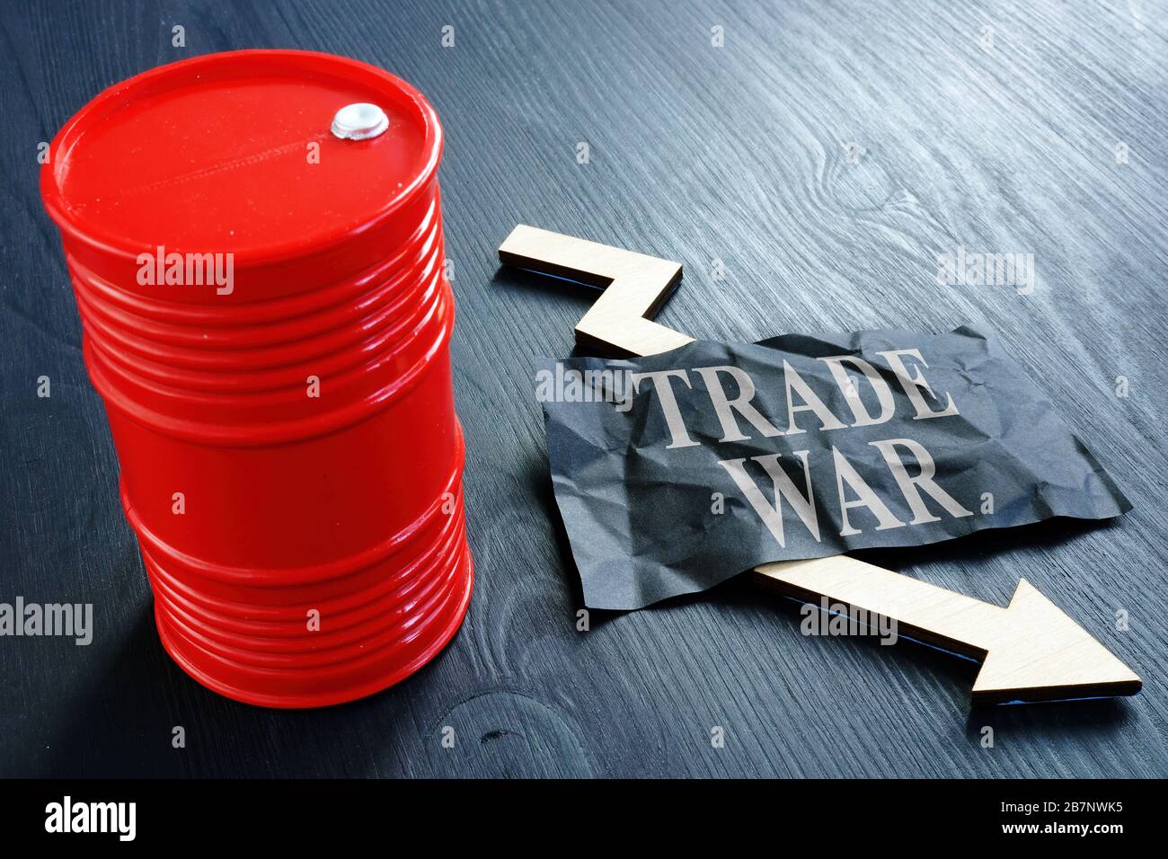 Oil Barrel with inscription trade war and falling arrow as concept of dropping prices. Stock Photo