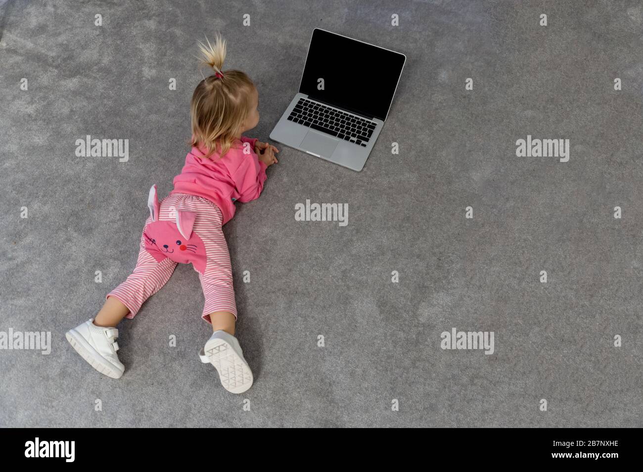 Toddler laying on floor and watching tv on laptop Stock Photo - Alamy