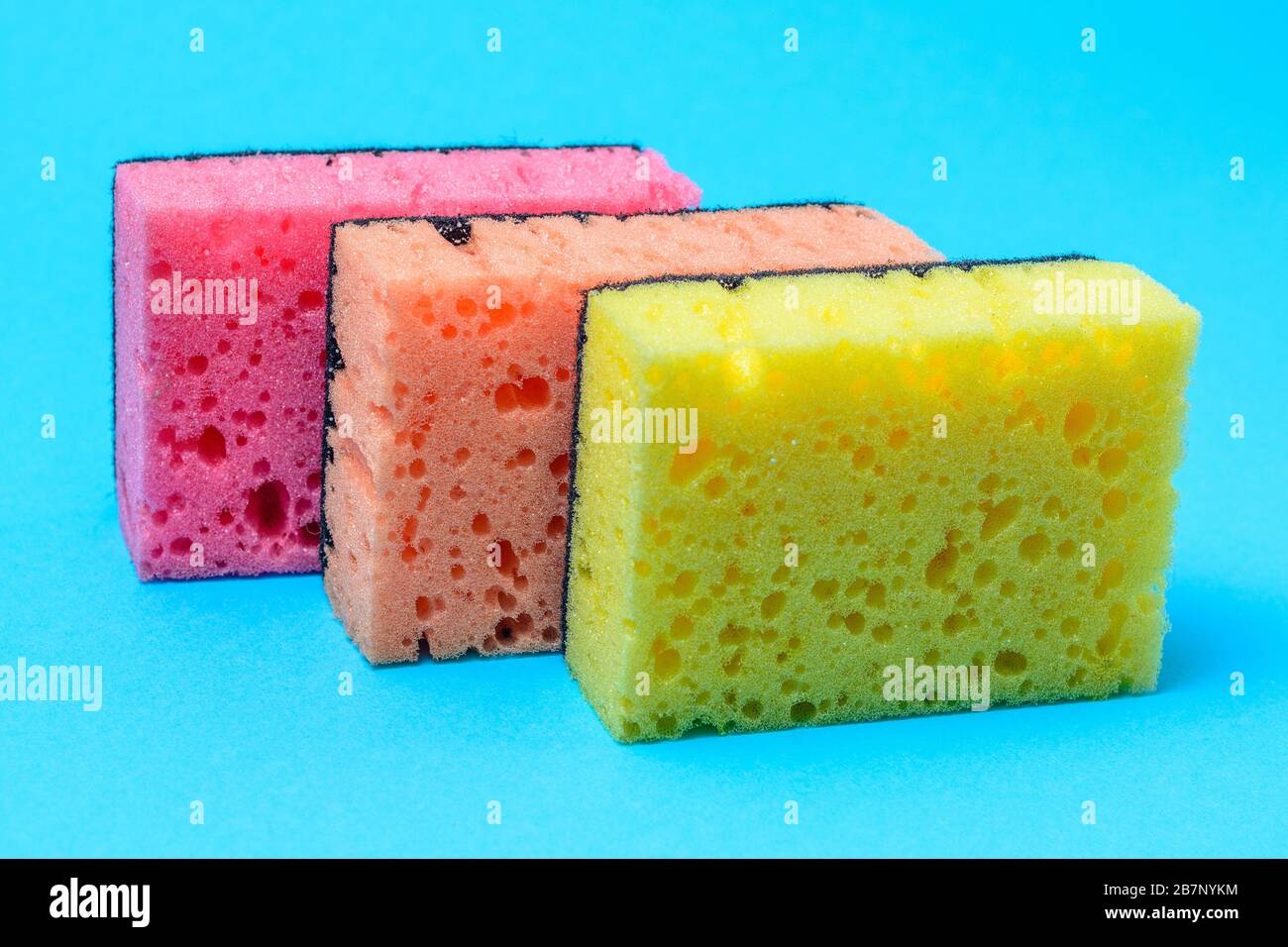 Sponges for washing and cleaning multicolored on blue background. Stock Photo