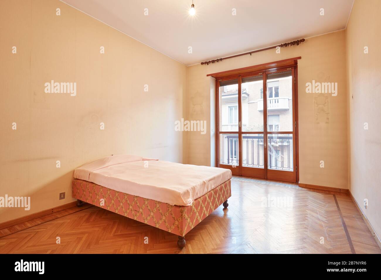 Bedroom with pink bed cover in old apartment interior Stock Photo
