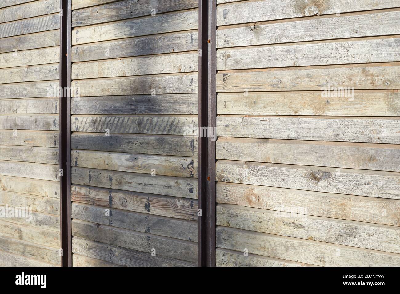 Wooden texture background with vertical metal bars in sunlight Stock Photo