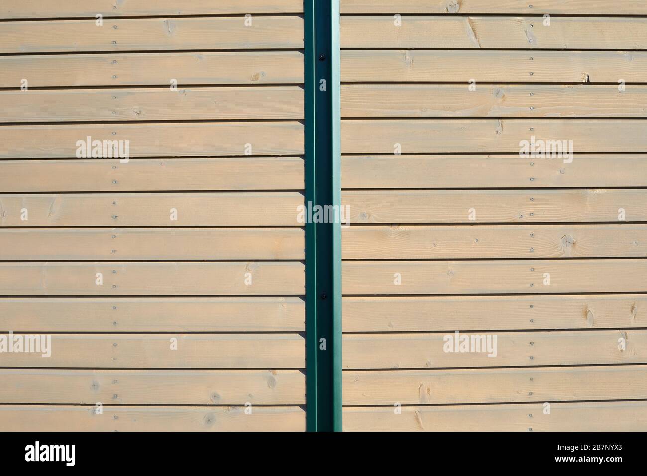 Wooden texture background with planks and green metal bar in sunlight Stock Photo