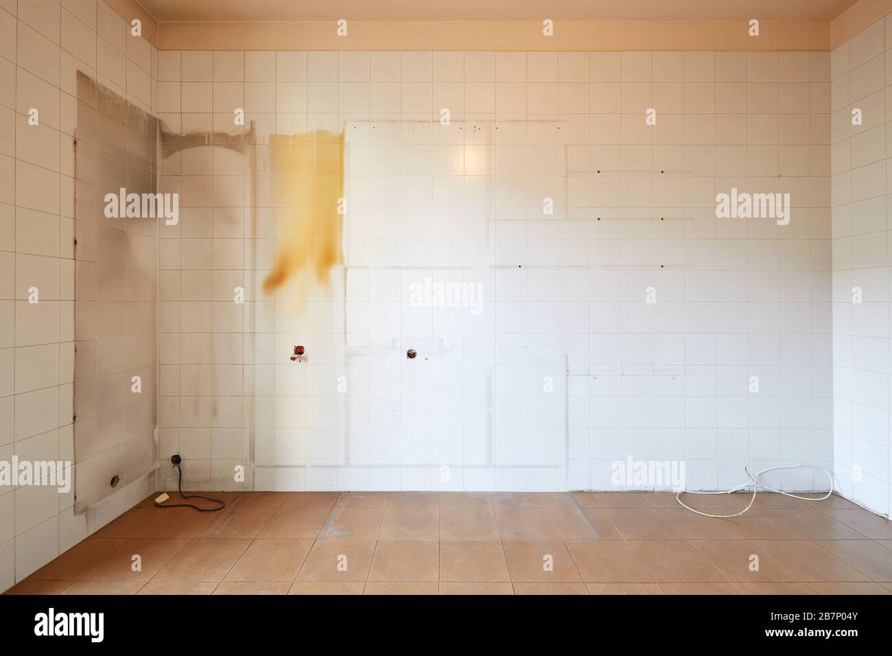 Empty, old kitchen interior with stained, tiled wall Stock Photo