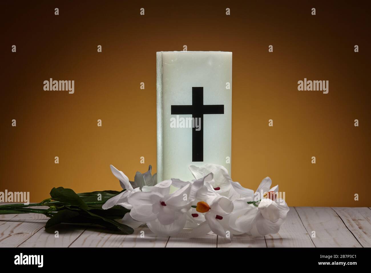 Glowing White Wax Christian Candle With Artificial Flowers Stock Photo