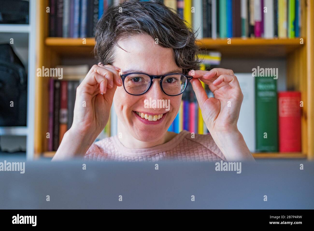 Young woman working from home. Caucasian short hair employee woman with glasses working online from home on computer laptop Stock Photo