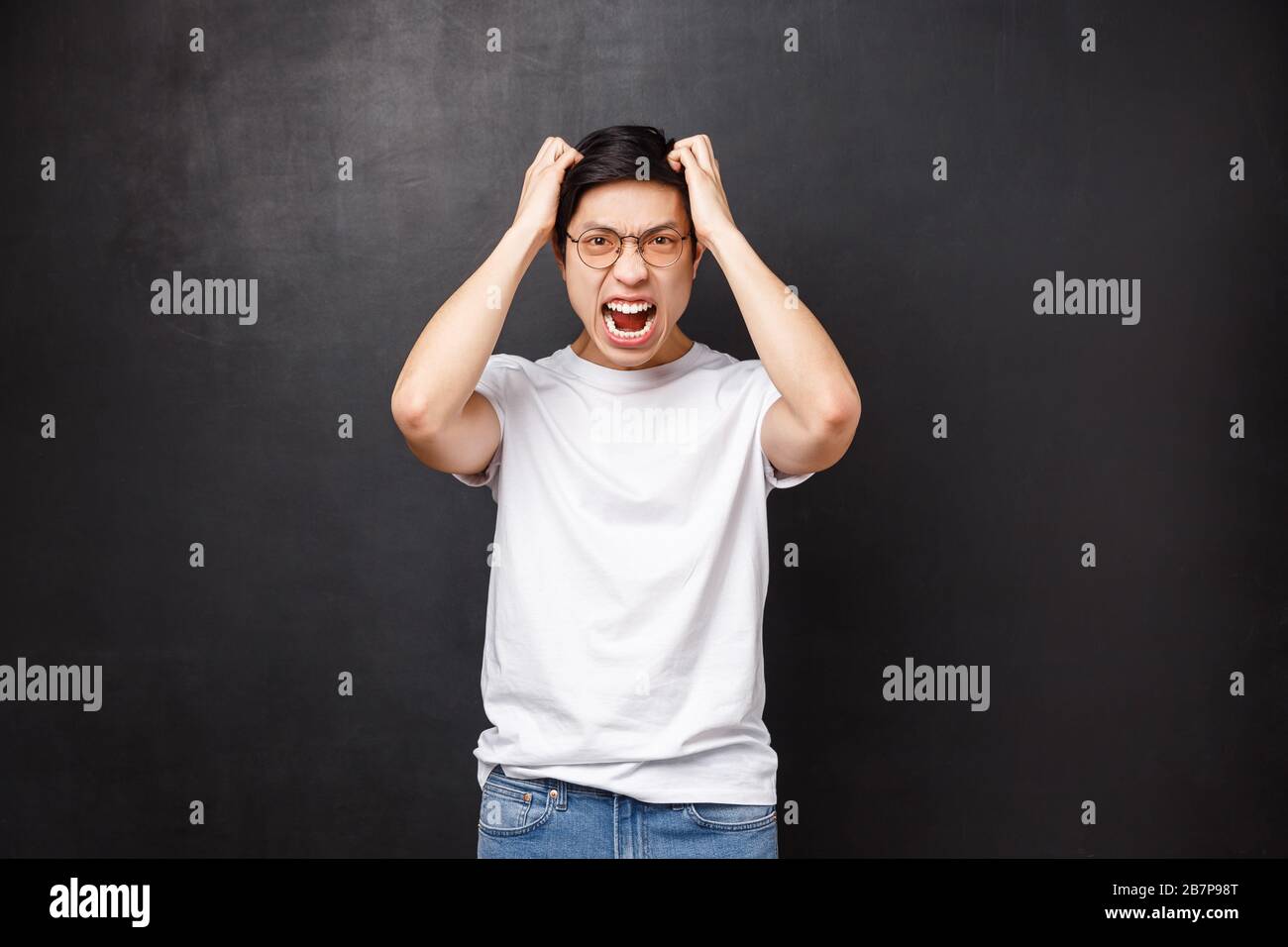 Angry and pissed-off bothered young asian guy losing temper, screaming ...