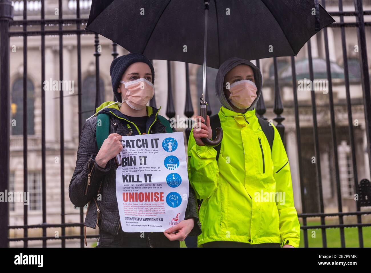 Belfast, Northern Ireland, UK. 17th Mar, 2020. 17th March 2020. Belfast City Hall. A small group of Unite Union members wearing surgical masks held a small protest outside Belfast city hall to highlight the plight of workers in the hospitality industry during the Coronavirus pandemic. They moved from City hall to Chichester Street and on to Church lane. Credit: Bonzo/Alamy Live News Stock Photo