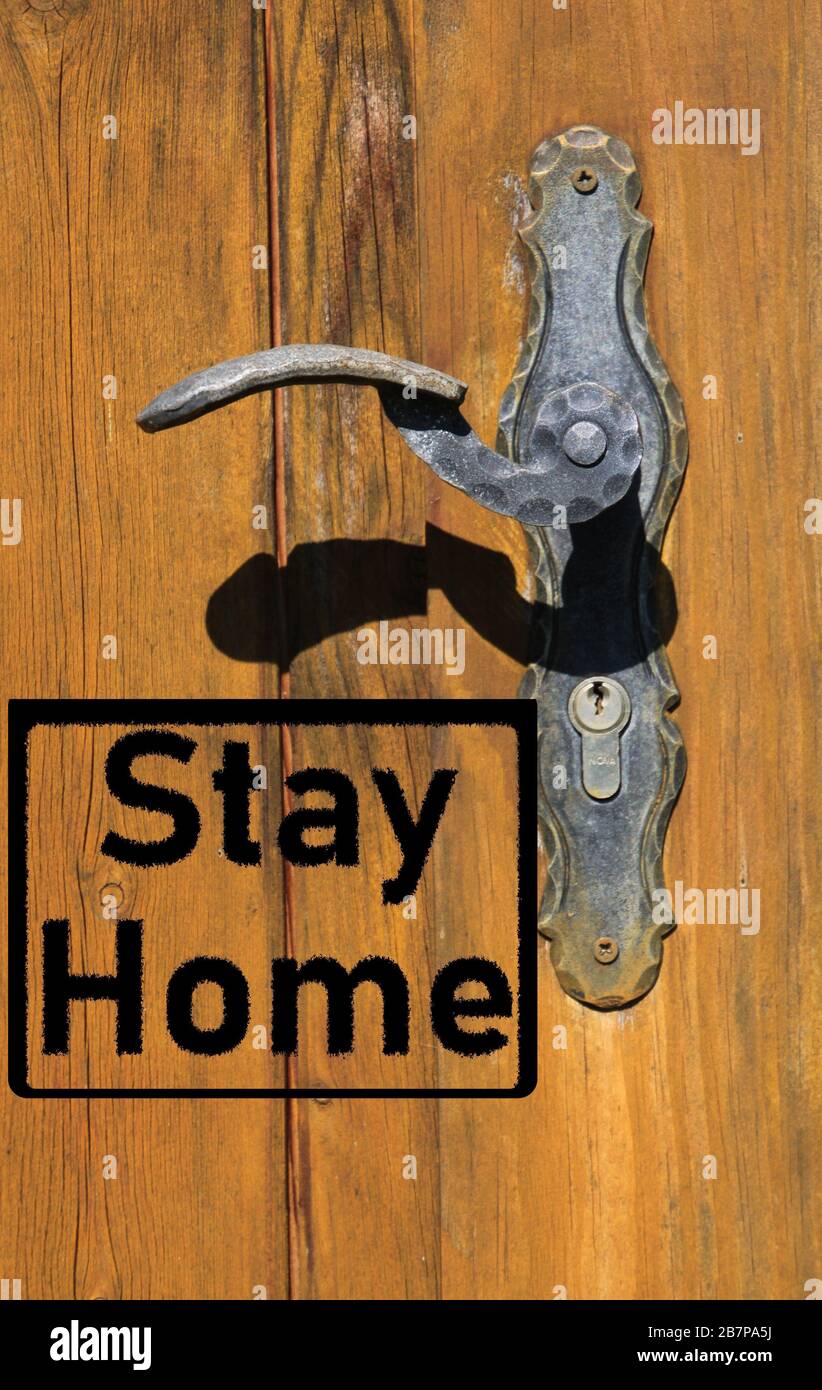 Corona virus covid-19 quarantine protection symbol concept: Text stay home on isolated old retro door with handle Stock Photo