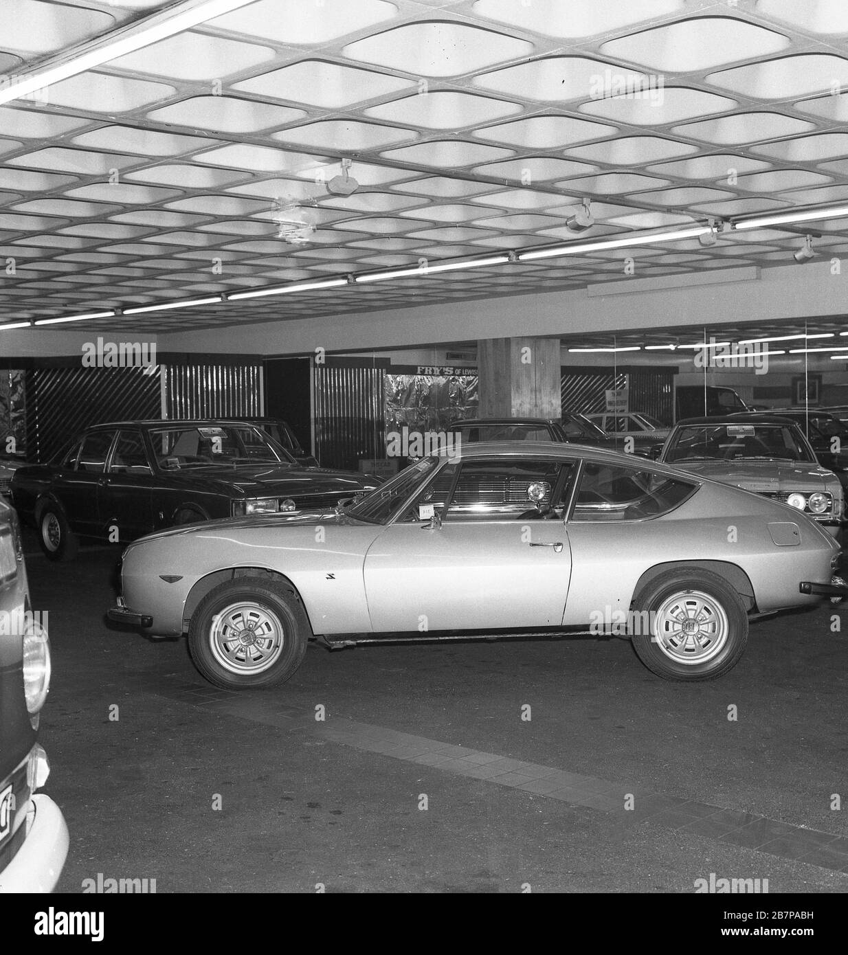 1970s, historical, sports coupe motorcar of the era parked in the car showroom of Fry's of Lewisham, South East, London, England, UK. The car, possibly a version of the Ford Mustang, was known as a 'Fastback Ford. Stock Photo